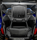Close-up of the rear cargo area of a blue Honda Talon 1000 featuring an open Cooler/Cargo Box with a hinged lid, showing its empty interior. The vehicle’s interior structure and part of the roll cage are visible in the background.