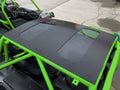 A Wild Cat Xx Aluminum Roof/Top With Sunroof is installed on a bright green off-road vehicle. Two transparent sunroof panels reveal the interior, including steering wheel and seats. The vehicle is parked on cracked concrete.