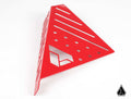 The Assault Industries Drivers Dead Pedal Cover for Polaris Slingshot is a red, triangular metal bracket with slotted and circular holes, featuring a right-angle fold, geometric cut-outs, and a black triangular logo in the bottom right corner.