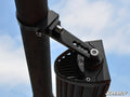 An Aluminum Tube Clamp secures an LED light bar to a round pipe under a blue sky with clouds. The clamp uses bolts and features adjustable teeth for positioning. The image shows the SuperATV logo in the bottom right corner.