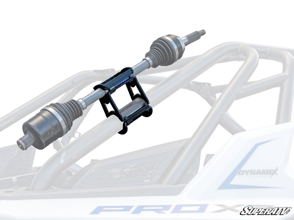 The Spare Axle Cage Mount is shown in black metal, securely holding a drive axle on an off-road vehicles roll cage. The semi-transparent view highlights its function for axle storage or transport, with the SuperATV logo visible in the corner.