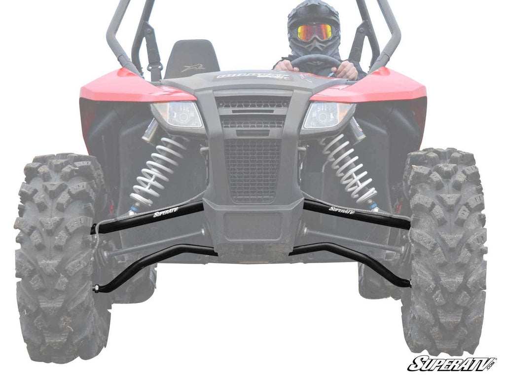 A red off-road ATV with large, rugged tires and exposed suspension is shown from the front. The driver wears a helmet and goggles. Two black Arctic Cat Wildcat Sport High Clearance A-Arms are attached to the front suspension, boosting durability and clear