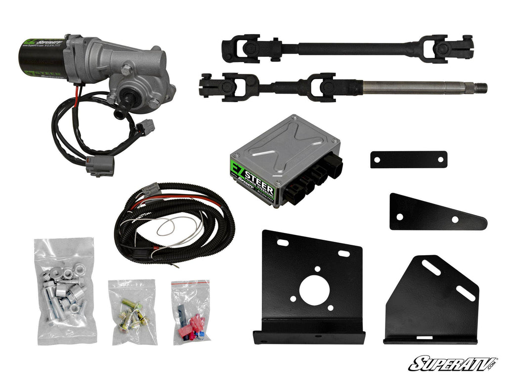The Arctic Cat Wildcat Trail Power Steering Kit is shown, featuring a motor, E-Z STEER control module, wiring harness, hardware bags, U-joint shafts, and black metal mounting brackets arranged on a white background.