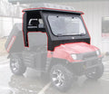 A red utility vehicle with large rugged tires is parked outdoors, featuring the Armor Tech Windshield/Top/Rear Glass Ranger 800—an angular black metal cab enclosure with glass windshield, roof, and windows covering the front seats and dashboard.