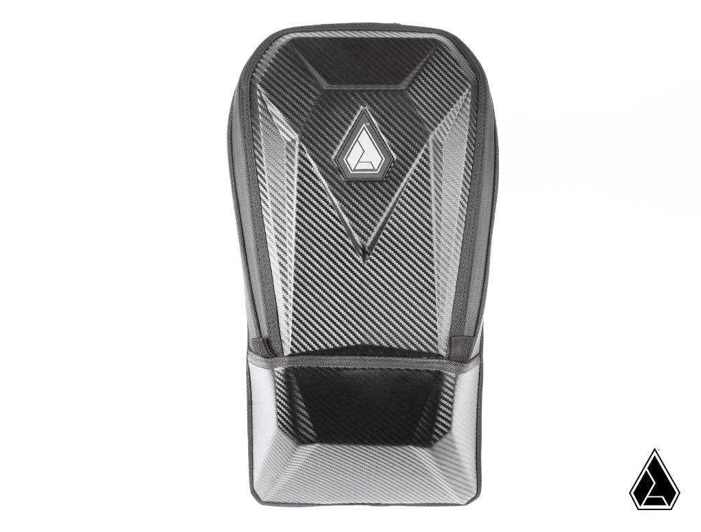 The Assault Industries RUXAK Glovebox for Can Am Maverick X3 features a sleek black carbon fiber look with a textured finish, geometric silver logo on the front, molded angular design, and a modern, minimalistic style.