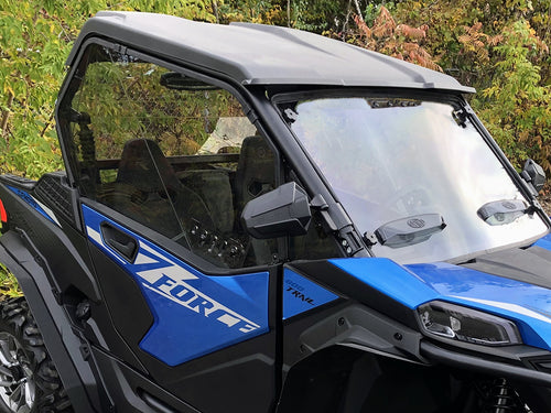 A close-up of a blue and black off-road utility vehicle with CF Moto Z-Force 800-950 Trail Vented Scratch Resistant Polycarbonate Upper Doors Kit (Tinted) 2023+ installed. "Fort" appears in bold on the door, with green foliage in the background.