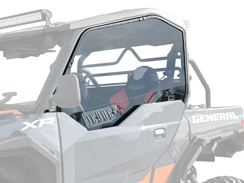 A close-up of a gray Polaris General XP shows the Hard Coated Polycarbonate Upper Doors Kit installed, featuring a clear full-size window on the driver’s side, plus roll cage, side mirror, bucket seat with harness, and GENERAL branding.