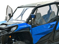 A Can Am Commander Venting Polycarbonate Upper Doors Kit (2021+) is installed on a blue and black off-road vehicle with clear doors, rugged tires, side mirrors, roll cage, and Commander labeled on the side. Shown close-up from the front side on a white ba