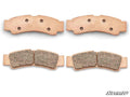 Four Kawasaki Teryx KRX Sintered Brake Pads are arranged in two pairs on a white background. Each pad features a curved shape, visible holes on the back, and textured friction material. The “SuperATV” logo appears in the bottom right corner.