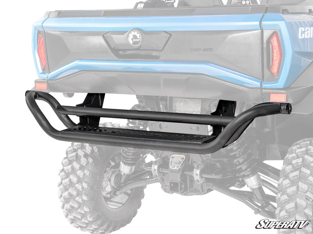 A Can-Am Commander 1000 Rear Bumper made of black tubular steel with a step is installed on the back of a blue off-road vehicle with lifted suspension and large tires. The SuperATV logo appears at the bottom right. Background is white.