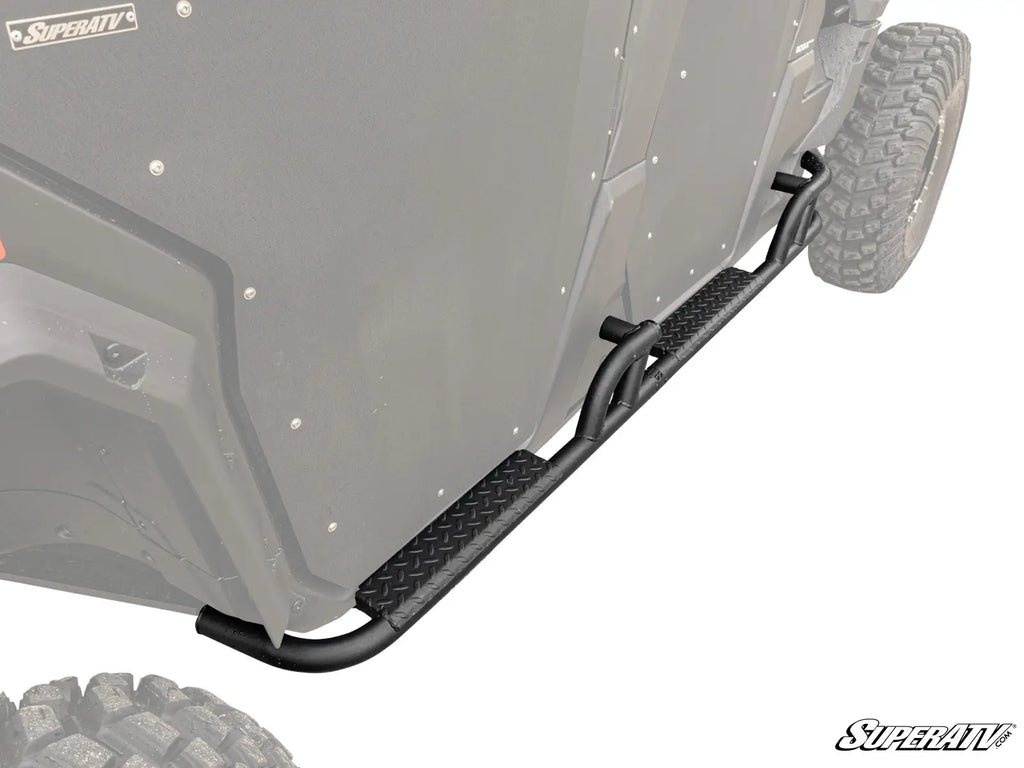 A close-up of Can-Am Defender Max Heavy Duty Nerf Bars—black metal with a diamond plate step—mounted below the doors and above rugged tires on an off-road utility vehicle, offering enhanced side protection.