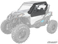 The driver’s side of a white off-road vehicle with large rugged tires features the Can-Am Maverick Sport Primal Soft Cab Enclosure Upper Doors in black. The faded vehicle highlights this accessory. The SuperATV logo is visible in the lower right corner.