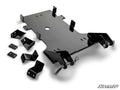 A Can-Am Commander Plow Pro Snow Plow Mount kit in black metal, with mounting brackets, plates, and hardware laid out on a white background. The large center plate has cutouts and attachment points; SuperATV logo is bottom right.