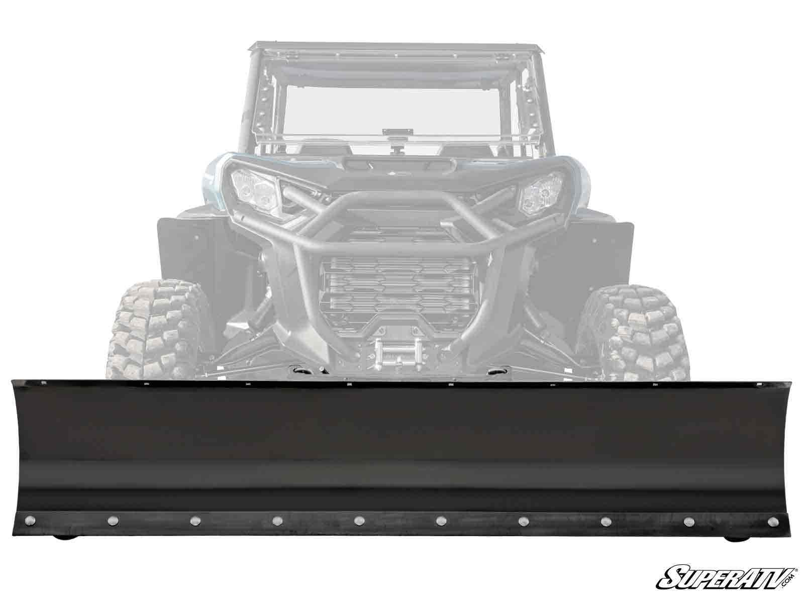 A Can-Am Commander Plow Pro Snow Plow, in black metal, is mounted to the front of a rugged-tired UTV. The UTV is partially faded to highlight the plow, with the SuperATV logo visible in the bottom right corner.
