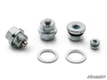 Four Up & Running Can-Am Oil Plug Kit plugs in different sizes are lined up with washers in front. Each has a hex socket and threads. The image shows a white background and the SuperATV logo at the bottom right.