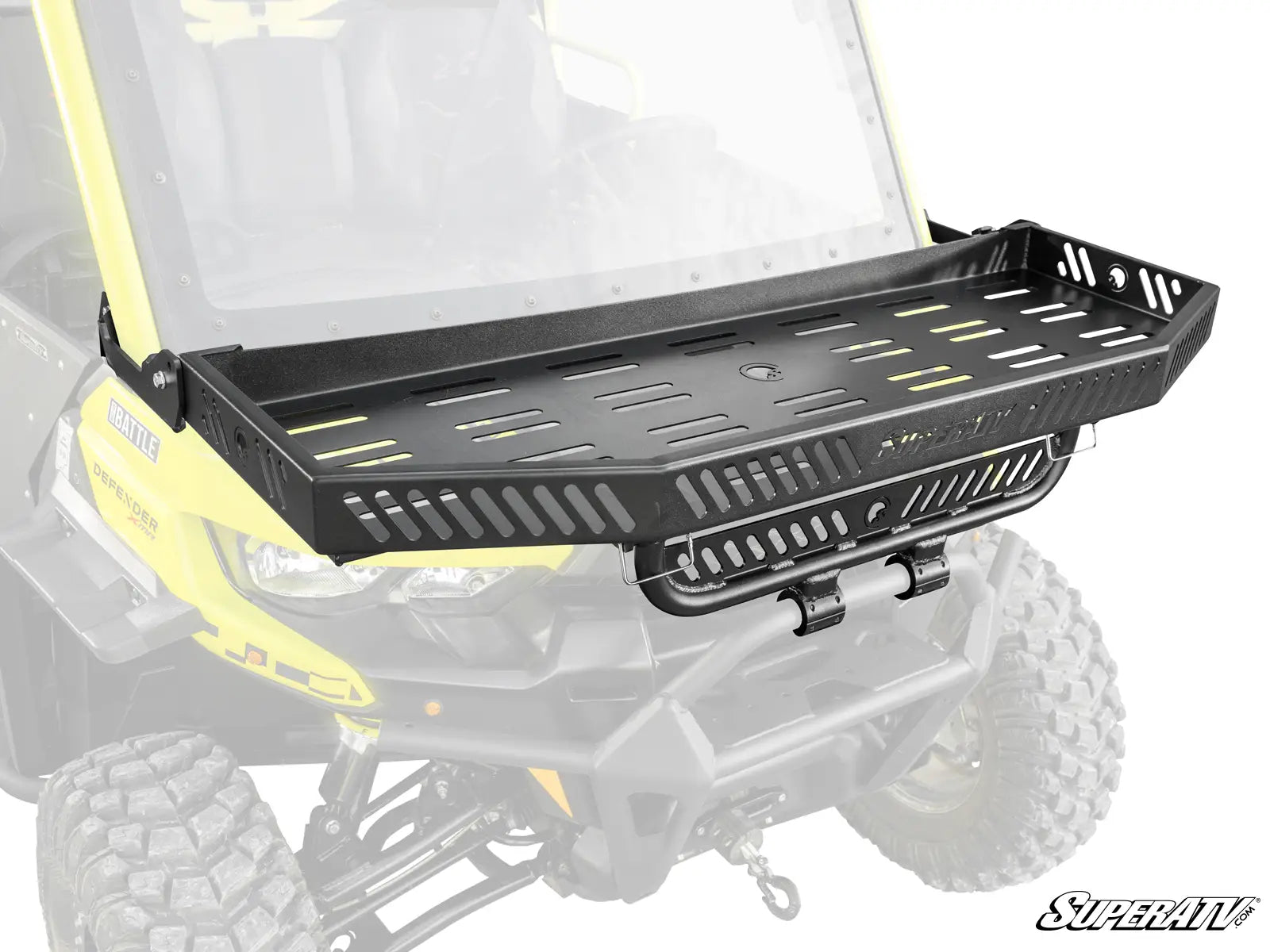 A Can-Am Defender Hood Rack in black metal with slotted sides and bottom is mounted to the front of a yellow off-road vehicle with large tires. The image spotlights the rack’s attachment points and sturdy build, with the vehicle faded in the background.
