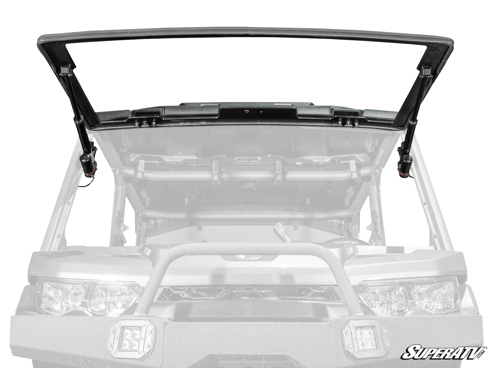 A grayscale image shows a Can-Am Defender with the MaxDrive Power Flip Glass Windshield, featuring a black, open flip-up design mounted in front. The SuperATV logo appears in the bottom right corner, emphasizing the windshield.