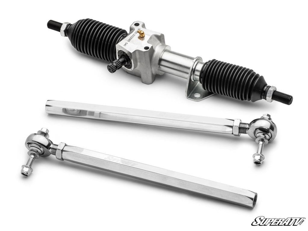 The Can-Am Defender HD7 RackBoss 2.0 Rack and Pinion is displayed with two black rubber boots above chrome tie rods with spherical rod ends on a white background. The SuperATV logo appears in the bottom right corner.