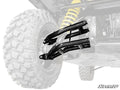 Close-up of a rugged off-road vehicle’s rear suspension, showcasing Can-Am Defender HD10 Atlas Pro 2 Rear Offset A-Arms and a yellow coil spring. The large tire is faded to highlight the new parts. SuperATV logo appears in the bottom right.