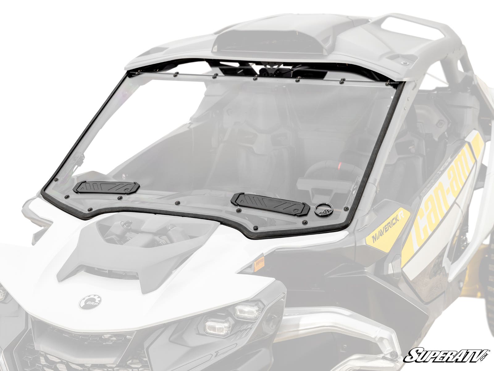 A Can-Am Maverick R Vented Full Windshield with a black frame and vents is installed on a white and yellow Can-Am Maverick side-by-side, set against a white background. The SuperATV logo is in the bottom right corner, highlighting the windshield.
