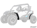 A Can-Am Maverick Sport features Low Profile Fender Flares in black on the front and rear wheel wells, emphasized against a faded backdrop. The SuperATV logo is displayed in the bottom right corner.
