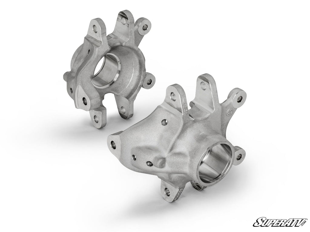 Two Up & Running Can-Am Maverick Rear Knuckles made of silver metal with smooth machined surfaces and multiple mounting holes are shown from different angles on a white background. The SuperATV logo appears in the bottom right corner.
