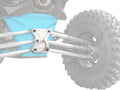 Close-up of a Can-Am Maverick X3 Billet Radius Rod Plate and silver suspension arms beneath a bright blue differential cover, with a rugged tire on the right. The faded tire and side draw focus to the metallic plate and suspension geometry.