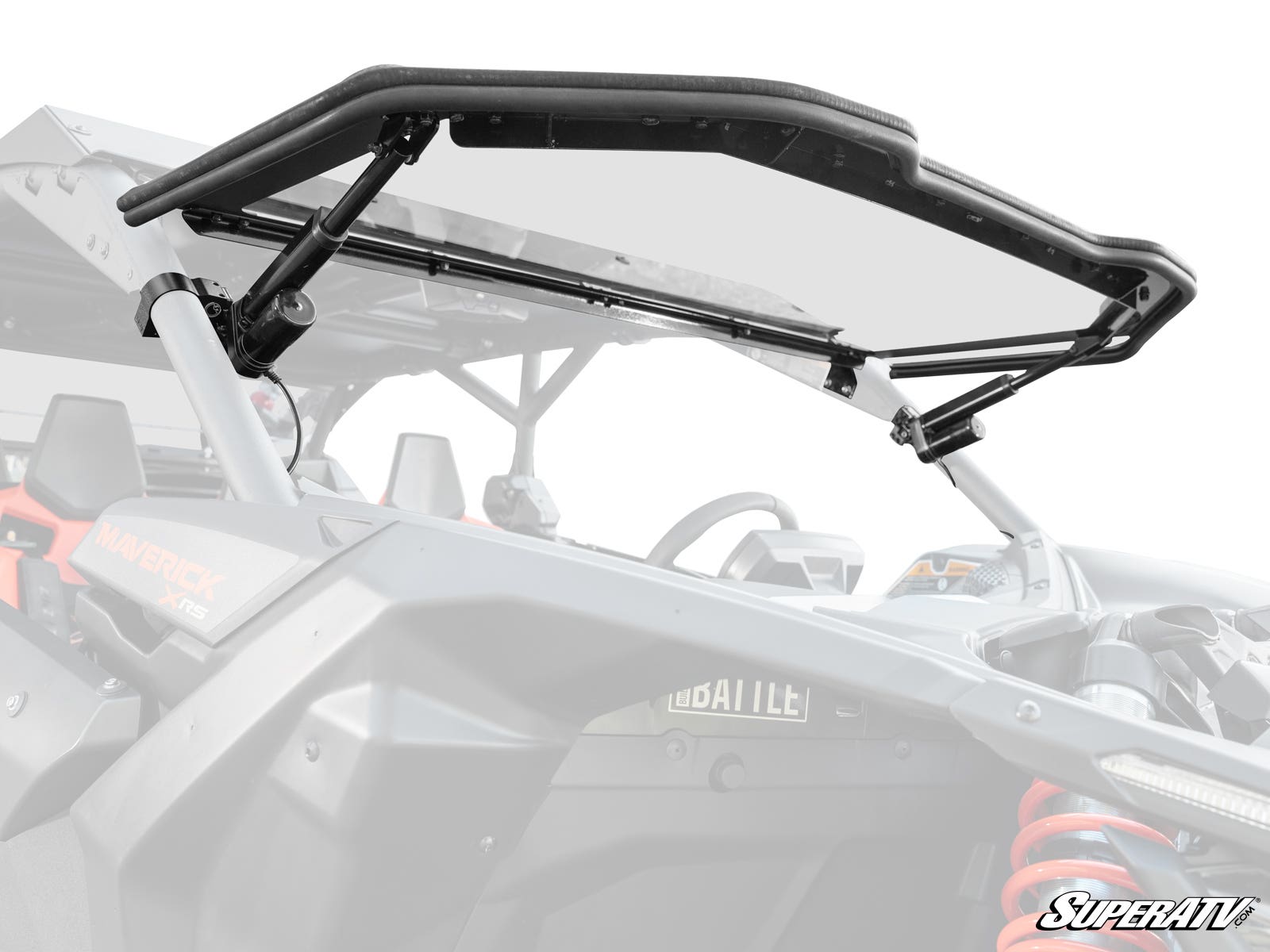A close-up of a Can-Am Maverick X3 MaxDrive Power Flip Windshield, shown tilt-open with black metal brackets attached, reveals the UTV’s cockpit and roll cage. The SuperATV logo appears in the bottom right corner.
