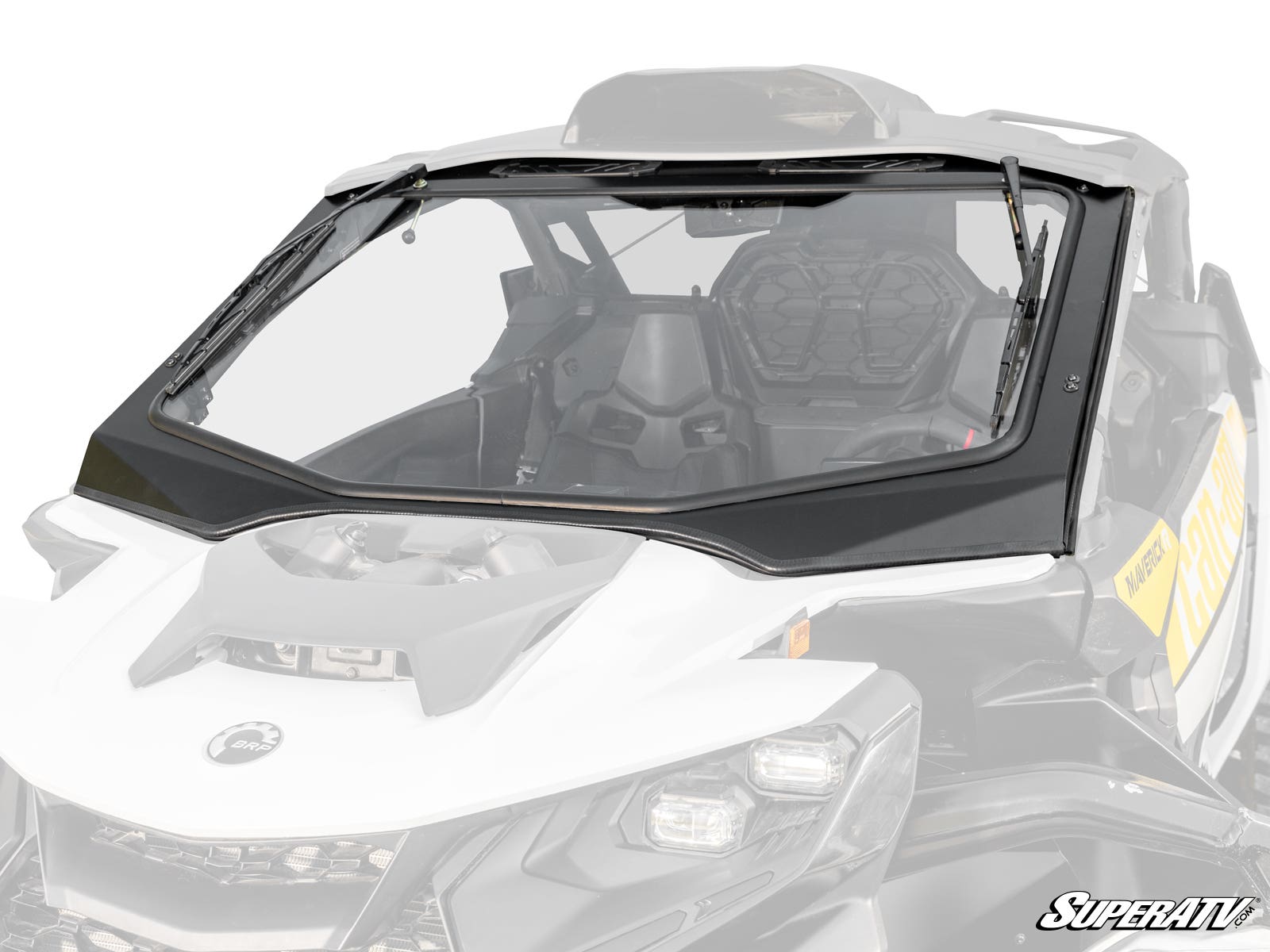 A Can-Am Maverick R Glass Windshield with a black frame is installed on a white off-road vehicle, showing part of the seats. The vehicle features angular styling and displays the SuperATV logo in the lower right corner.
