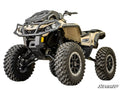 A tan and black Can-Am Outlander ATV with large off-road tires, elevated suspension from a 5 Lift Kit, front bumper guard, and detailed bodywork. OUTLANDER appears on the side; SuperATV logo is in the lower right corner.