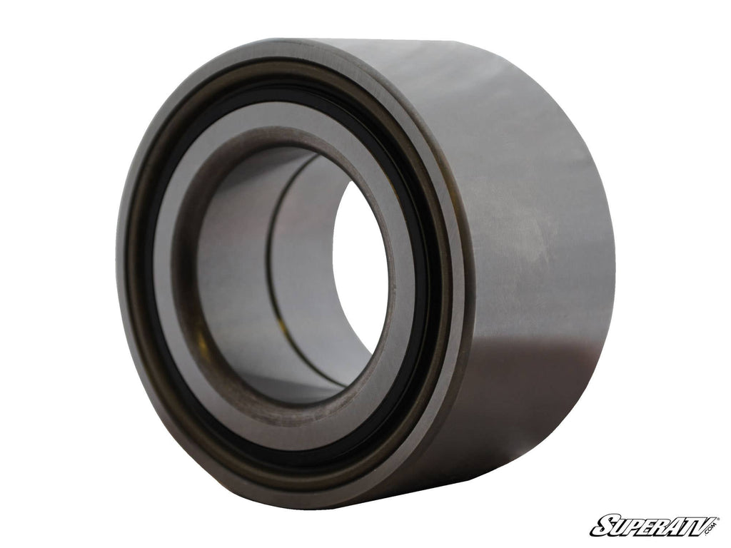 A close-up photo of a Can-Am Renegade Rear Trailing Arm Bearing, showing its smooth, shiny cylindrical metal surface and dark inner ring; the SuperATV logo appears in the lower right corner on a white background.