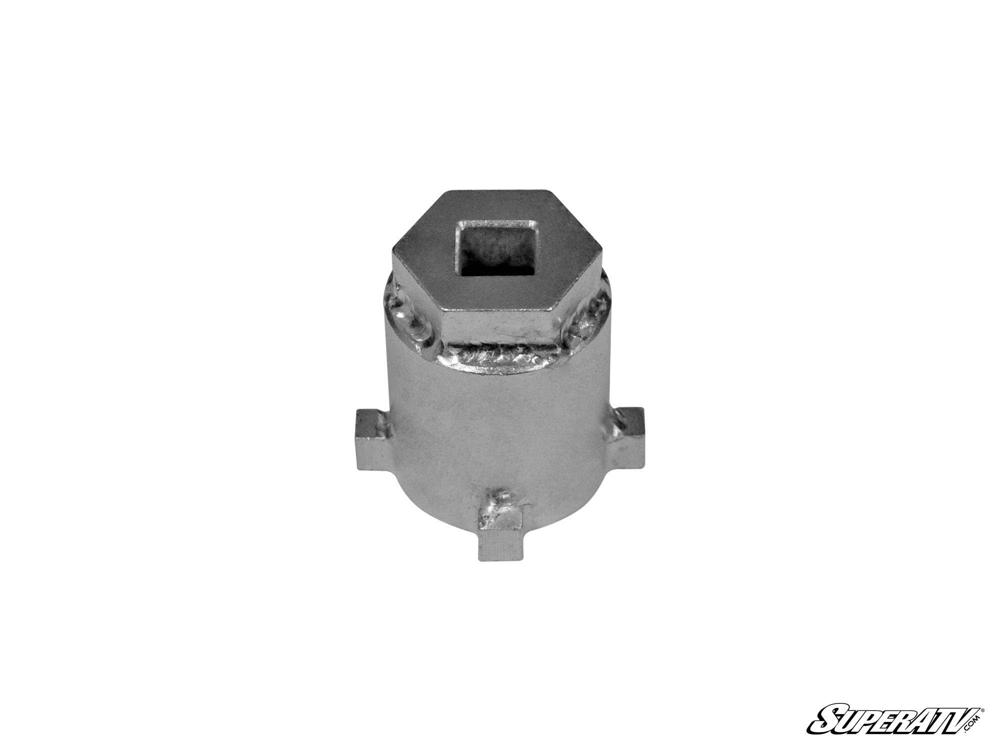 The Can-Am Pinion Gear Removal Tool is a metal socket with a hexagonal top opening and four protruding tabs on its cylindrical body, shown against a white background with the SuperATV logo in the bottom right corner.