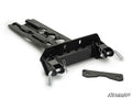 The Can-Am Maverick X3 Plow Pro Snow Plow Mount is a black metal plate with two large pins secured by clips, hardware slots, an extra flat bracket, and the SuperATV logo in the lower right corner on a white background.