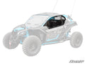 A Can-Am Maverick X3 with most of its body faded out highlights a black Hard Cab Enclosure Upper Door on the driver’s side. The vehicle features large rugged tires, visible suspension, and “SuperATV” branding in the lower right corner.