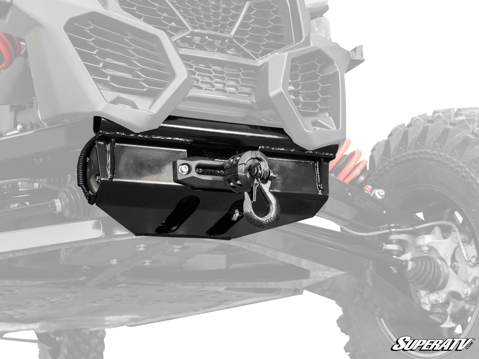 Close-up of a Can-Am Maverick X3 Ready-Fit Winch mounted under the front of an off-road vehicle with rugged suspension, red coil springs, and a black protective winch housing. The SuperATV logo is shown in the bottom right corner.