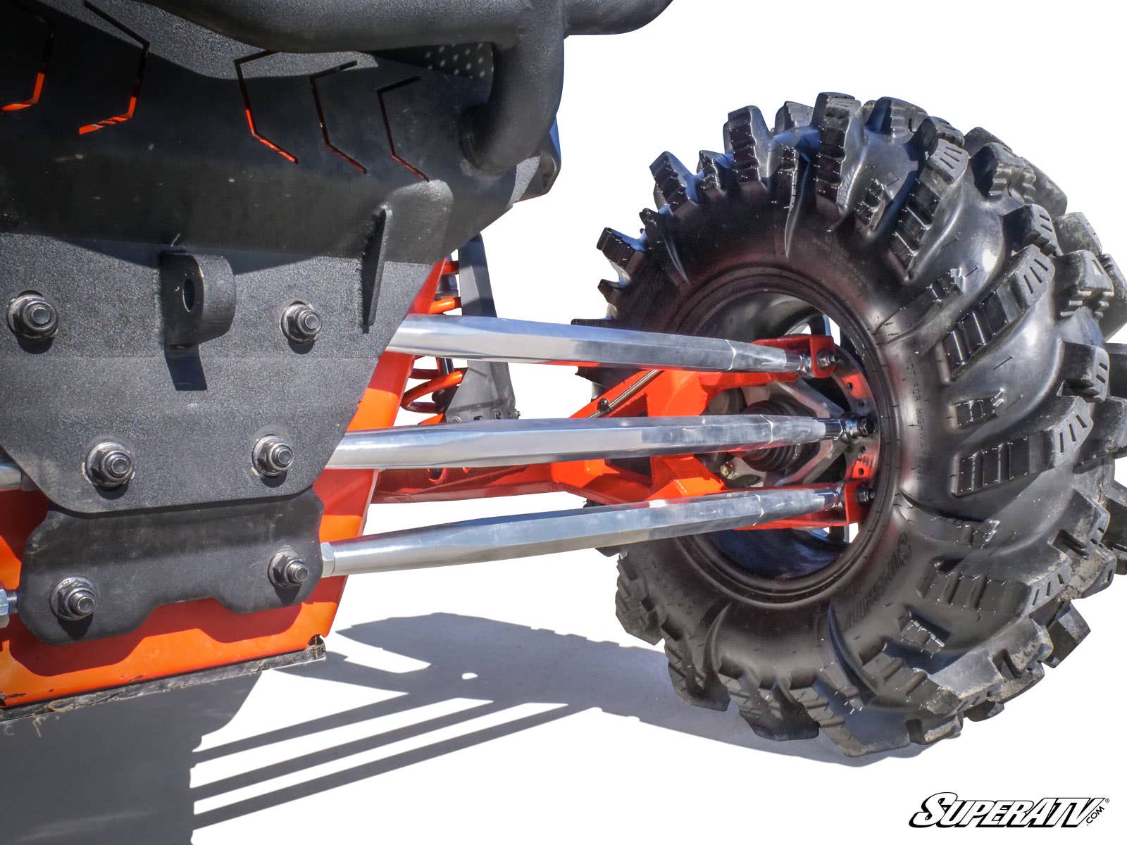 Close-up of Can-Am Maverick X3 Billet Aluminum Radius Arms connecting to a rugged tread tire on an off-road vehicle with an orange and black frame. SuperATV branding is visible in the bottom right corner.