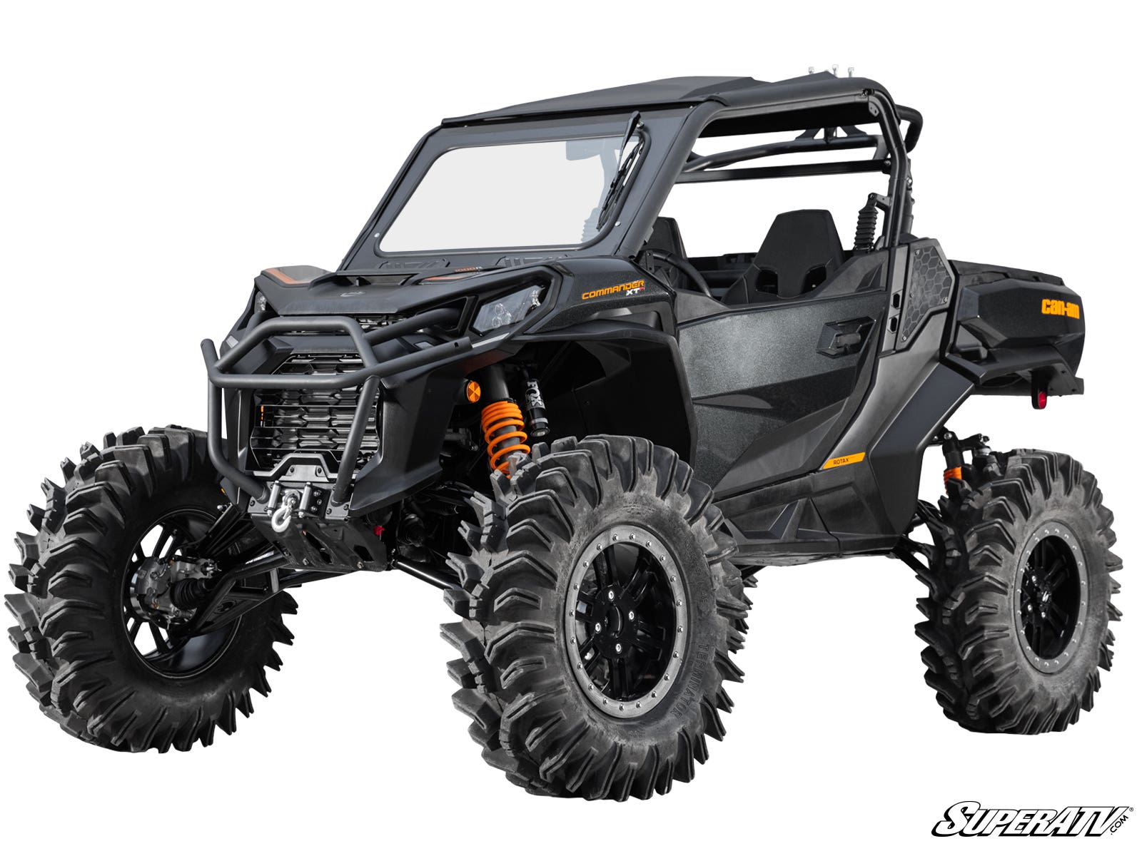 A Can-Am Maverick Sport with a 6 Lift Kit features black off-road styling, oversized mud tires, orange suspension springs, a roll cage, sturdy front bumper, closed doors, and a partially open windshield. SuperATV logo shown bottom right.