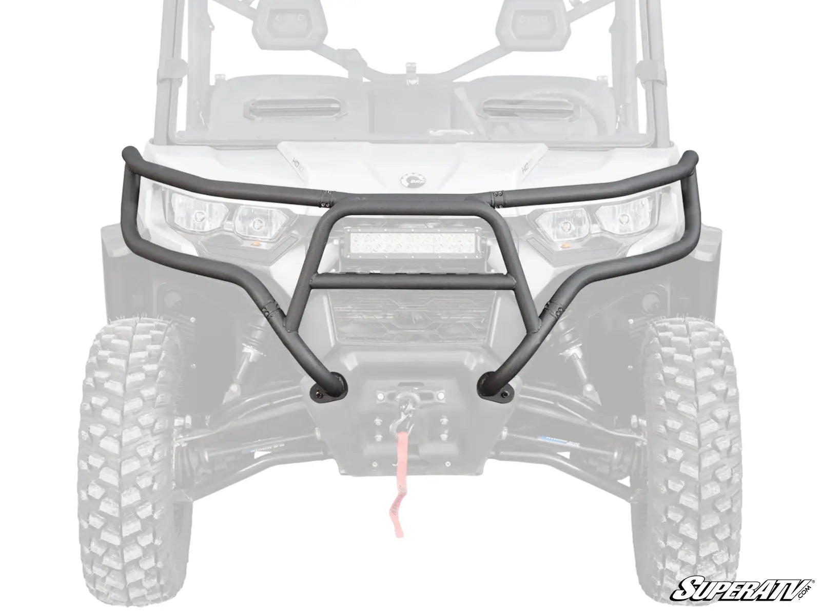 The Can-Am Defender Front Bumper, a black, heavy-duty bumper with tubing and a central protective plate, is mounted on an off-road vehicle. It has a winch opening for rugged terrain. The SuperATV logo appears in the lower right corner.