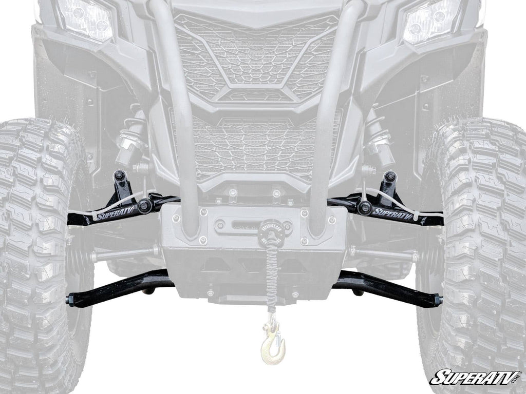 Close-up of Can-Am Maverick Trail High Clearance 1.5 Forward Offset A-Arms, showing large off-road tires, SuperATV suspension arms, a central winch with hook, and rugged front grille. Faded background vehicle highlights the new A-Arms.