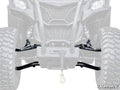 Close-up of Can-Am Maverick Trail High Clearance 1.5 Forward Offset A-Arms, showing large off-road tires, SuperATV suspension arms, a central winch with hook, and rugged front grille. Faded background vehicle highlights the new A-Arms.