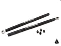 Two black Assault Industries Turret Style Heavy Duty Tie Rods for Can-Am Maverick X3 lie parallel on a white background, each with a metal circular joint at one end. Four small black nuts are below the rods. The Assault Industries logo is in the bottom ri