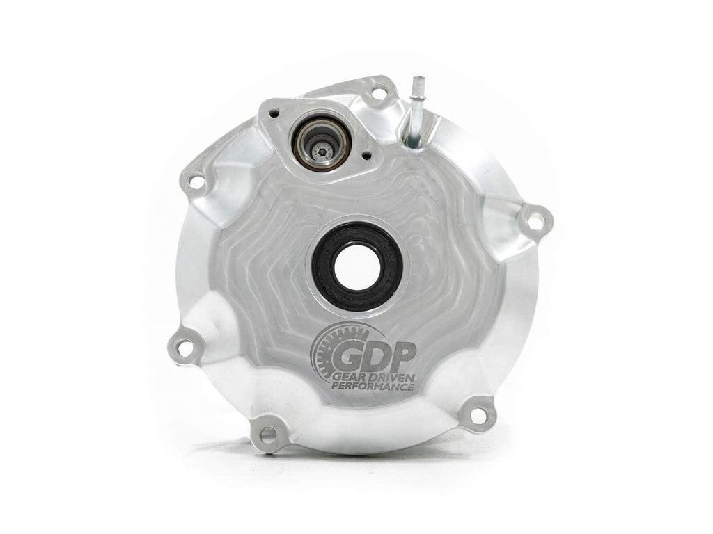 A circular, silver metal cover for the Can-Am Maverick X3 Pin Locker Differential features four bolt holes, a central black opening, a smaller upper opening, machined patterns, and the “GDP Gear Driven Performance” logo etched near the bottom.