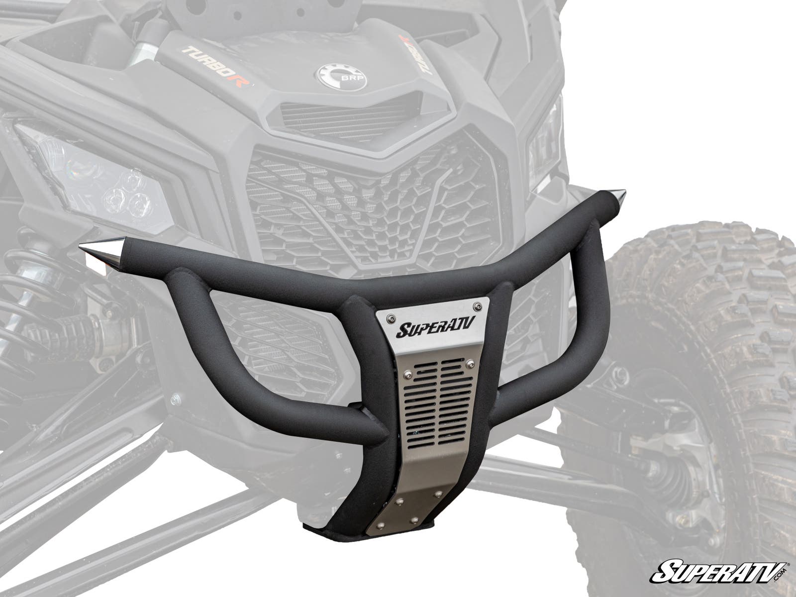 A Can-Am Maverick X3 Prerunner Front Bumper in matte black and metal, labeled SuperATV, is digitally superimposed on a rugged ATVs front, highlighting its fit and design with visible suspension, tires, and grille.