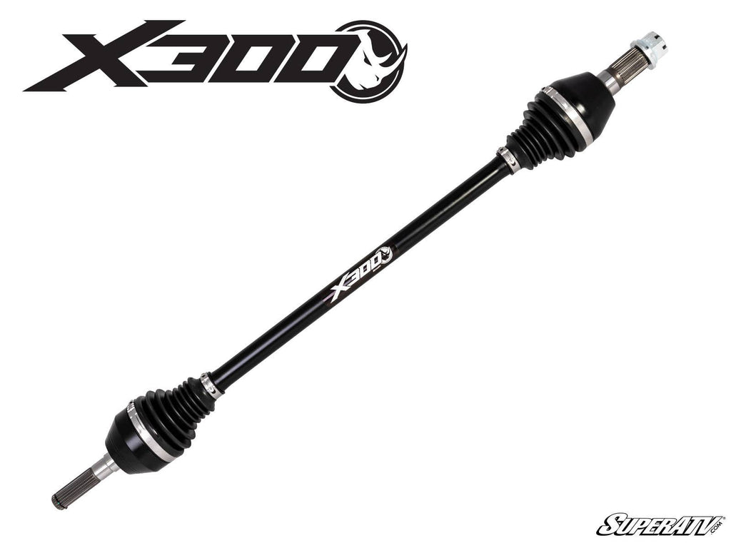 A Can-Am Maverick X3 Big Lift Kit Heavy-Duty Axle X300, black with metal ends and rubber boots, is displayed diagonally on a white background. The X300 logo appears in the top left; the SuperATV logo is in the bottom right.