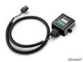 The Honda SpeedDoctor Speedometer Correction Kit is a black electronic control box with a digital display, three green buttons, and the SuperATV logo. It connects via a long coiled cable ending in a black plastic plug with visible colored wires.