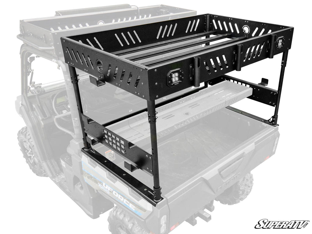 The CFMOTO UForce 1000 Outfitter Bed Rack is a black, heavy-duty metal rack with two tiers, slotted panels, tie-down points, and reinforced edges—mounted on the bed of a utility vehicle shown in partial transparency.