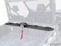 A CFMOTO UForce 1000 Bed Winch is mounted inside the black UTV cargo area, featuring a red strap on the winch hook. The UTV cab interior and roll cage are visible, with the SuperATV logo in the bottom right corner.
