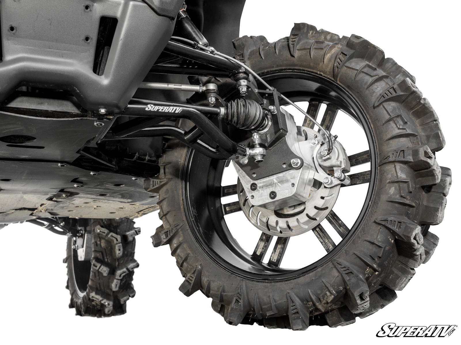 Close-up view of a CFMOTO UForce 1000 with 6 Portal Gear Lift, showcasing the rugged tire on a black rim, suspension arms, disc brake, and SuperATV logo. Another tire is visible in the background.