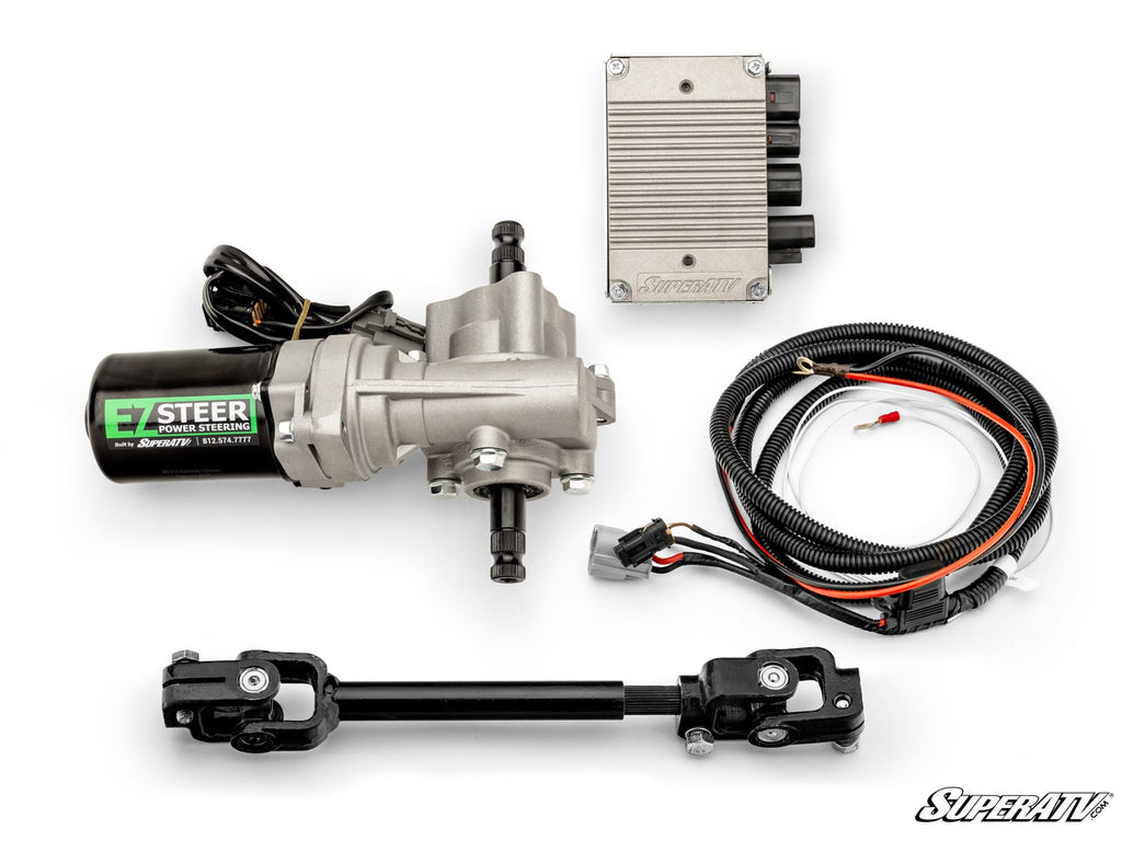 A CFMOTO UForce 600 Power Steering Kit is shown with an electric motor assembly, ECU module, wiring harness, and two black steering shaft components neatly arranged on a white background. The SuperATV logo is in the bottom right corner.