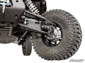 Close-up of a CFMOTO ZForce 950 HO with the 4 Portal Gear Lift shows rugged, deep-tread tire, exposed shocks, control arms, CV axle, brake disc, and a black metal skid plate. SuperATV logo appears bottom right.